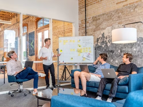 Small business SEO consultant leading office meeting around a table.