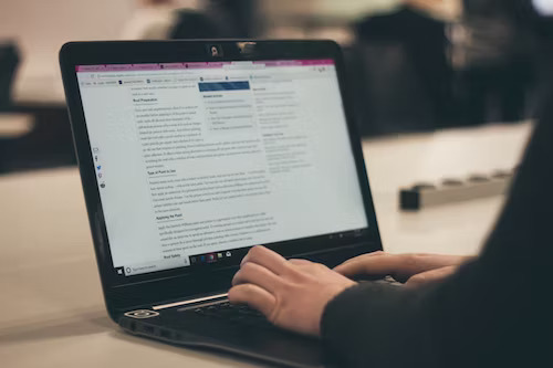 Small business owner typing content marketing tips on a laptop.