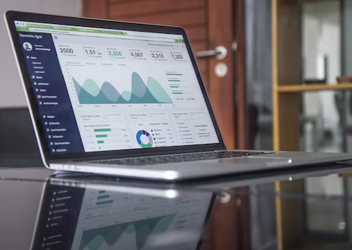 Laptop displaying online customer retention strategies graph on a table.